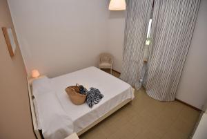 a small room with a bed with a basket on it at Residence Blùmarine in Silvi Marina