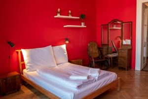 Un dormitorio con una pared roja y una cama. en Clown and Bard Hostel, en Praga