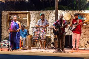 eine Gruppe von Menschen auf einer Bühne, die Musik spielen in der Unterkunft Zanzibar Sunrise at Bandas in Matemwe