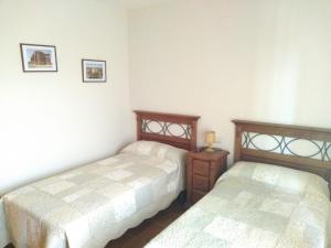 JunzanoにあるApartamentos Aires de Guaraのベッドルーム1室(ベッド2台、ナイトスタンド、ベッド2台付)