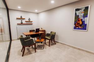 a room with a desk and chairs and a painting at BUSINESSPALAS DELUXE in Izmit