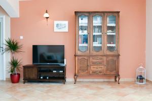 a living room with a tv and a wooden hutch at Villa Sun in Čilipi