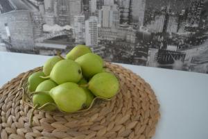 una cesta de manzanas verdes delante de una ventana en Boulevard en Kremenchuk