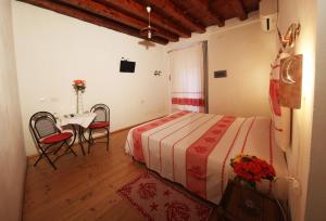 Schlafzimmer mit einem Bett, einem Tisch und Stühlen in der Unterkunft Note Sulla Piazza in Cagliari