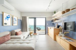 a living room with a couch and a tv at ELADIA Suites in Neos Marmaras