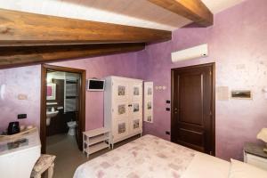 a bedroom with purple walls and a bed and a sink at Il Viaggio in Diano Marina