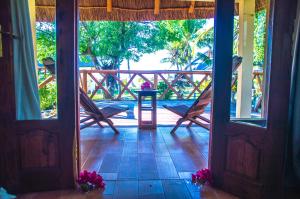 Vilancool Beach Resort في فيلانكولوس: باب مفتوح على شرفة مع الزهور على الأرض