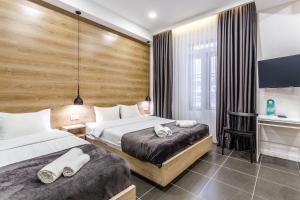 a hotel room with two beds and a desk at 8 Rooms Apartotel On Meidan in Tbilisi City