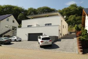 um carro branco estacionado em frente a uma garagem em Riethelblick em Volkesfeld