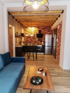 ein Wohnzimmer mit einem blauen Sofa und einem Tisch in der Unterkunft LM Luxury Central Loft in Larisa