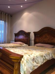 a bedroom with two beds with wooden headboards at Luxury City Center Tumanyan street Apartment in Yerevan