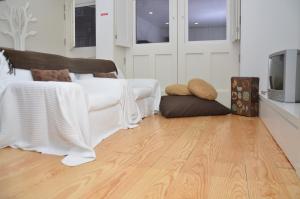 ein Wohnzimmer mit weißen Möbeln und Holzboden in der Unterkunft Jenny and Carmie TOWN HOUSE in Viana do Castelo + 5 Fotos