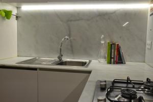 a kitchen counter with a sink and a stove at Jenny and Carmie TOWN HOUSE in Viana do Castelo