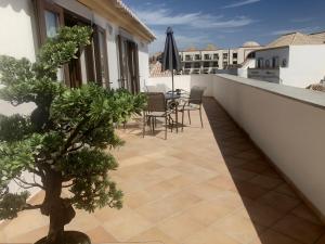 a balcony with a table and chairs on a building at Loft 1º de Maio in Tavira