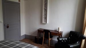 1 dormitorio con escritorio, silla y cama en L'ancienne comédie en Semur-en-Auxois