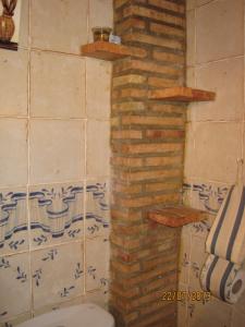 a bathroom with a toilet and a brick wall at Apartamentos Rurales Casa del Tio Juan in Olocau del Rey