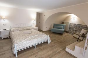a bedroom with a bed and a blue chair at Alle Scalette B&B in Lauria Inferiore