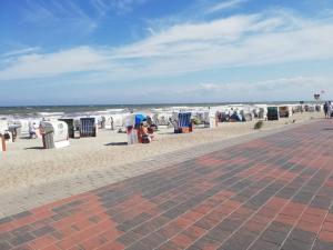 a beach with chairs and trash cans and the ocean at Haus Hopp - Bungalow in Dahme