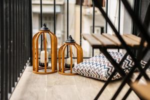 three lanterns sitting on a balcony with a bench at LM Luxury Central Loft in Larisa