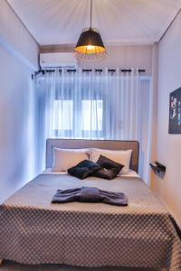 Un dormitorio con una cama con una ventana grande. en LM Luxury Central Loft, en Larisa