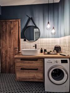 ein Badezimmer mit einem Waschbecken und einer Waschmaschine in der Unterkunft LM Luxury Central Loft in Larisa