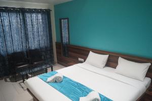 1 dormitorio con 2 camas y pared verde en Hotel Sai Sharada, en Pune