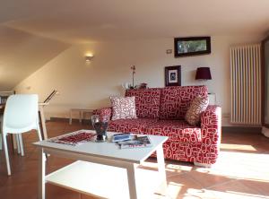 a living room with a red couch and a table at Alloggio turistico La Casa del Vignola in Viterbo
