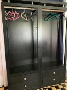 a black cabinet with hangers and shoes at Design District Retreat in Miami