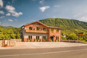 um edifício ao lado de uma estrada com uma montanha em Hotel Tsesi em Tsesi