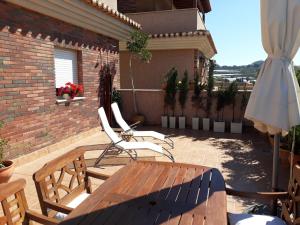 un patio con mesa de madera y sillas y un edificio en Terraza y Playa Costa Tropical en Torrenueva