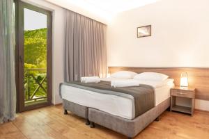 a bedroom with a large bed and a large window at Hotel Tsesi in Tsesi