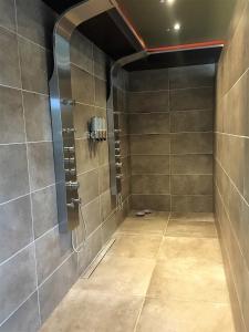 a bathroom with a shower with a phone on the wall at Suite & Wellness in Breskens