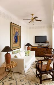 un soggiorno con divano bianco e TV a schermo piatto di Riad Le J a Marrakech