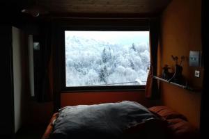 a bedroom with a window with a view of snow covered trees at La Casina nella Valle in Serina