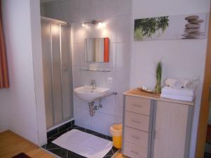 een witte badkamer met een wastafel en een douche bij Apart Bella Cascata in Kappl