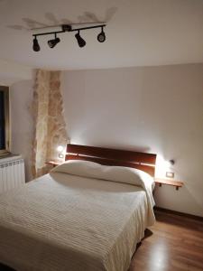 una camera da letto con un letto bianco e luci sul muro di Historical Domus ad Anagni