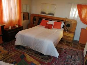 a bedroom with a large bed with red pillows at Rocks And Aloes Guest Lodge in KwaGamalakhe