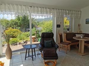 a living room with a chair and a table at Südharzblick in Neustadt