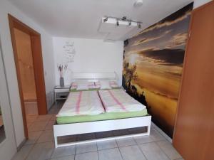 un letto in una stanza con un dipinto sul muro di Südharzblick a Neustadt