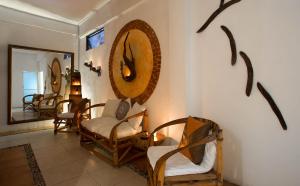 a living room with chairs and a mirror on the wall at Hotel Xbalamqué Boutique & Spa in Cancún