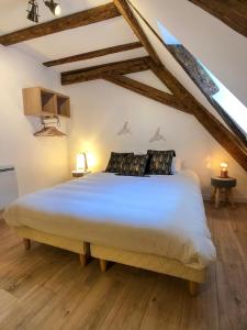 a bedroom with a large white bed with wooden floors at Beauty & The Beast - Old Town Cosy Apartments in Colmar