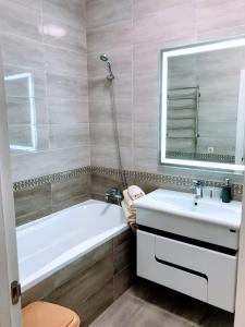 Odessa的住宿－Beautiful Apartments by the sea，带浴缸、水槽和镜子的浴室