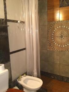 y baño con aseo blanco y ducha. en City Apartment en Buenos Aires