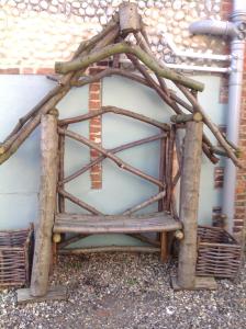 a structure made out of twigs and a building at The Bittern in Blakeney