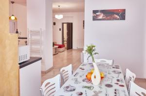 a dining room with a table with a vase on it at Gabizz Apartments in Constanţa