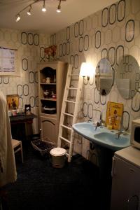 a bathroom with a sink and a shelf with mirrors at Maison d'hôtes LE LAVOIR in Fontaines