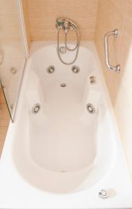 a white bath tub in a bathroom with a shower at Abadía Burgos Camino Santiago in Burgos