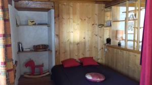 Schlafzimmer mit einem Bett mit roten Kissen und einem Fenster in der Unterkunft Gite Seguret in Gresse-en-Vercors