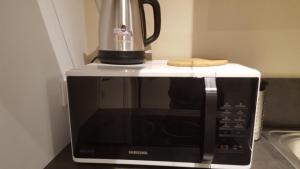 a coffeemaker sitting on top of a microwave at Le studio Cosy d'Angelique et David avec Parking in Rambouillet