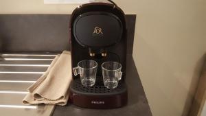 a black coffee maker with two glasses on a counter at Le studio Cosy d'Angelique et David avec Parking in Rambouillet